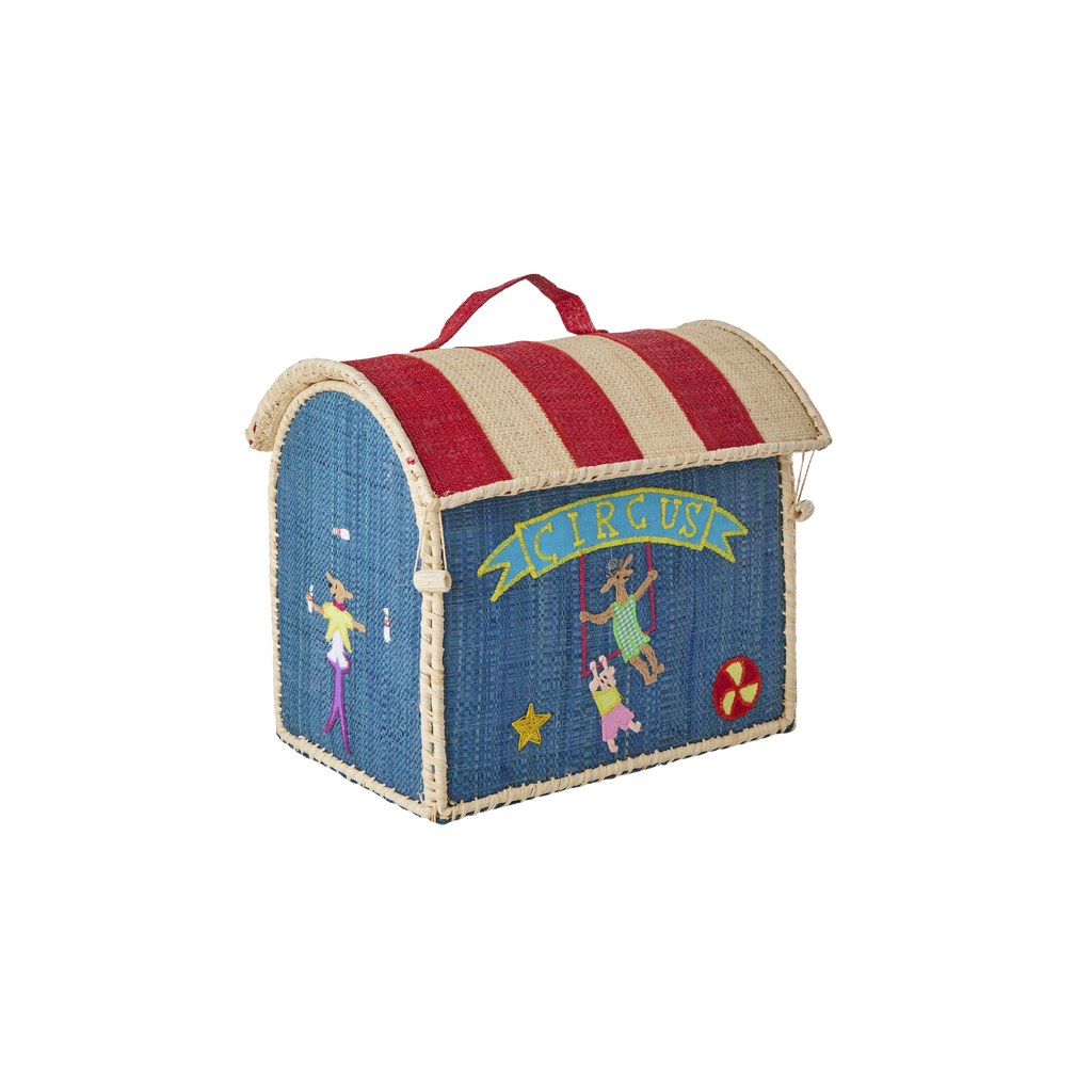 Introducing the Raffia Kids Bag with Circus Theme: a rectangular, woven basket bag boasting blue sides, a red and beige striped roof, and delightful circus-themed embroidered details—including performers, a star, a ball, and a yellow “Circus” banner on the front. Thoughtfully handcrafted from durable raffia, this charming accessory perfectly combines playful style with long-lasting quality.