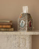 The Coral & Tusk Birdhouse Tissue Box Cover with embroidered birds and flowers sits on a white marble mantel beside vintage books against a beige wall.