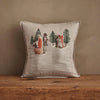 The Coral & Tusk Winter Foxes Pocket Pillow showcases embroidered fox, bear, and wolf figures among pine trees with snowy accents—ideal winter fox decor on a wooden surface.