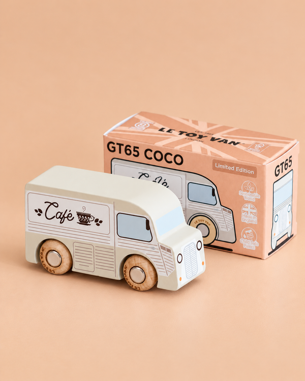 A wooden coffee van labeled “Café,” named No. 11 GT65 Coco and made in England, is placed beside its box, which reads “GT65 COCO Limited Edition.” Perfect for imaginative storytelling or thoughtful gifting, the scene is set against a soft beige background.