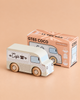 A wooden coffee van labeled “Café,” named No. 11 GT65 Coco and made in England, is placed beside its box, which reads “GT65 COCO Limited Edition.” Perfect for imaginative storytelling or thoughtful gifting, the scene is set against a soft beige background.