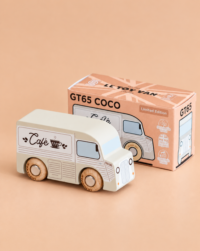 A wooden coffee van labeled “Café,” named No. 11 GT65 Coco and made in England, is placed beside its box, which reads “GT65 COCO Limited Edition.” Perfect for imaginative storytelling or thoughtful gifting, the scene is set against a soft beige background.