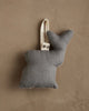 The Coral & Tusk Deer with Lights Ornament is a small, gray fabric deer with a white hanging loop, perfect for adding woodland charm to your Christmas tree, shown against a textured beige wall.
