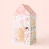 A pastel, house-shaped box with hand-painted flowers, a door, window, and a winged fairy. With a pink roof and light pink background, it’s perfect for gifting Cuddle + Kind Tiny Lily the Fairy or any fair trade handmade toy.