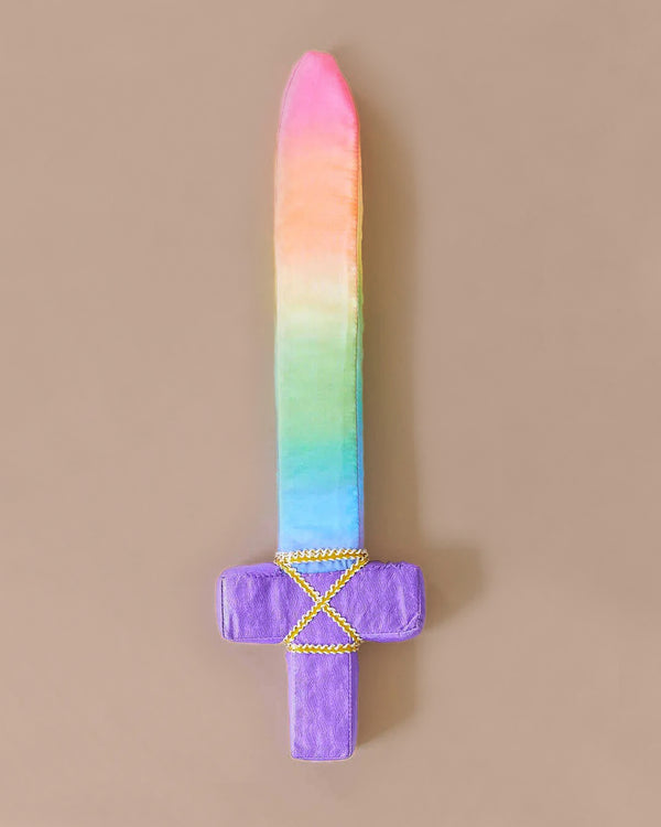 Introducing Sarah's Silk Soft Sword, a plush toy featuring a vibrant rainbow-colored blade and a purple handle that's perfect for pretend play. The sword showcases yellow crisscross stitching on the guard, set against a plain beige background—ideal for imaginative adventures with soft swords.