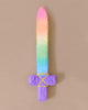 Introducing Sarah's Silk Soft Sword, a plush toy featuring a vibrant rainbow-colored blade and a purple handle that's perfect for pretend play. The sword showcases yellow crisscross stitching on the guard, set against a plain beige background—ideal for imaginative adventures with soft swords.