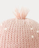 Close-up of the Cuddle + Kind Baby Octopus in Soft Coral Pink, featuring heirloom-quality Peruvian cotton yarn and a plush pom-pom top, shown against a plain light background.
