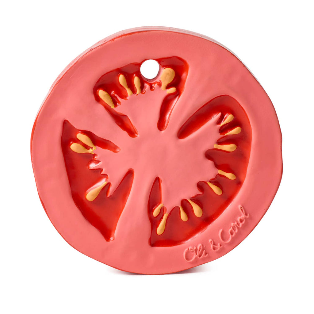 Renato the Tomato is a round, flat teething toy made from natural rubber, colored red and pink with yellow seed details, a small edge hole, and “Oli & Carol” embossed. It's an eco-friendly choice for babies.