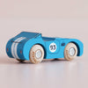 The No. 5 GT30 Coby, made in England, is a small blue wooden race car featuring white racing stripes, the number 93 on the side, and light-colored wheels—a classic racing toy that makes a charming addition to any collection.