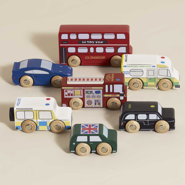 The London Toy Car Set features seven colorful wooden vehicles inspired by classic London transport, including a red double-decker bus and black taxi—perfect for plastic-free play.