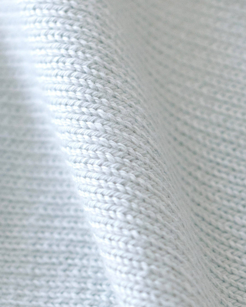 Close-up of the Cuddle + Kind Organic Cotton Baby Bunny Lovey in Baby Blue, featuring a soft ribbed texture, gentle folds, detailed stitching, and a smooth surface.