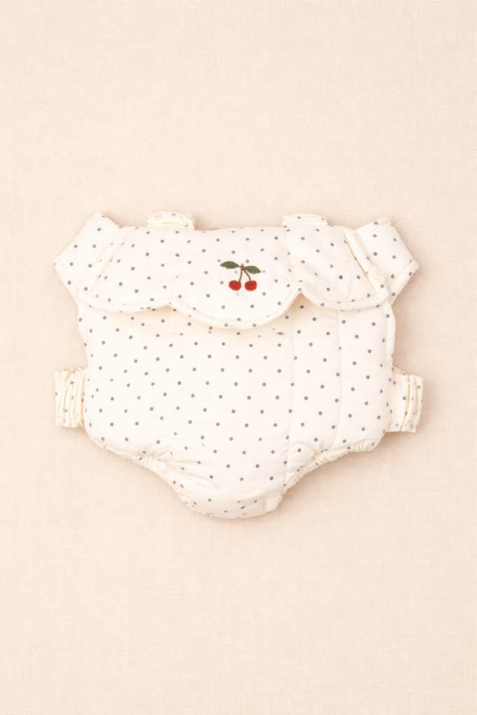 A cloth diaper and the Konges Sloejd Doll Carrier - Estate Dot rest neatly on a white surface.