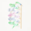 A Sarah's Silk Robin's Egg Blue Streamer Wand, adorned with Rainbow Streamers in soft pastel shades of pink, blue, and green, arranged in a flowing, whimsical pattern on a light background.