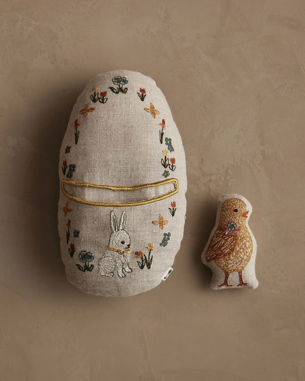 The Coral & Tusk Pocket Easter Egg features a plush embroidered egg with a white rabbit and flowers, plus a smaller bird-shaped toy with orange and brown details—charming accents for any Easter basket.