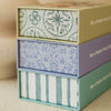 Stacked trio of puzzle boxes with eye-catching sides: the top showcases a green circular floral design, the middle sports a blue floral motif, and the bottom presents green and white vertical stripes. The Little Racers 40 Piece Mini set is the perfect woodland animal jigsaw puzzle for little ones, offering hours of imaginative play.