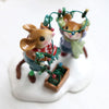 Two tiny, hand-sculpted Wee Forest Folk Merry & Bright collectibles depict mice in winter clothes untangling festive string lights on a snowy base—charming holiday miniatures for collectors.