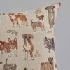 Coral & Tusk Dogs and Toys Pillow with an assortment of different dog breeds printed on a beige fabric, along with images of dog bones and a ball.