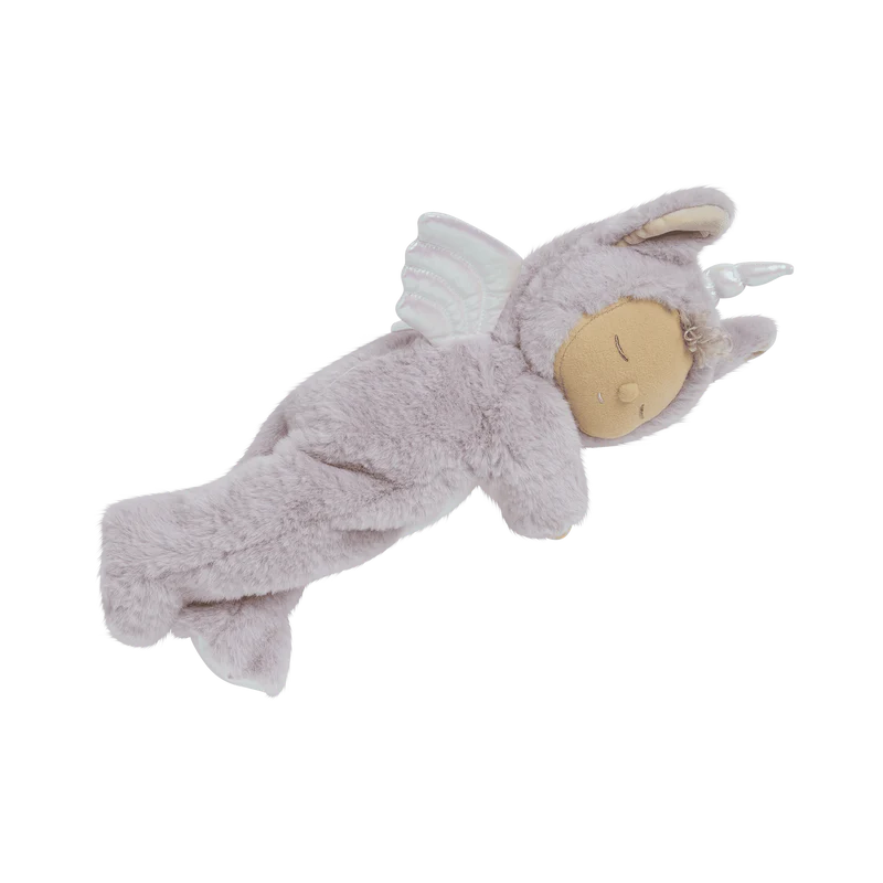 The Olli Ella Cozy Dinkum Doll Unicorn - Sweetpea is a plush baby doll in a gray, fluffy one-piece with a hood adorned with tiny animal ears and shimmering wings, showcasing a serene, sleeping expression.