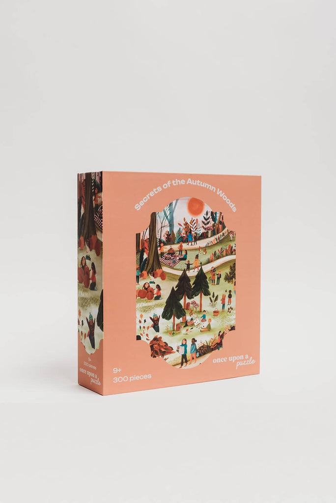 The Secrets of the Autumn Woods 300 Piece Puzzle comes in a peach-colored box featuring playful autumn forest artwork with people outdoors and includes a large illustrated reference poster.