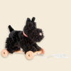 Pull-Along Walter, a plush black dog featuring a red plaid collar, is mounted on four wooden wheels and comes with a white pull string—creating an adorable pull-along toy set against a plain light background.