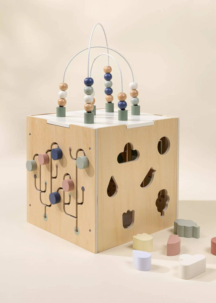 The Wooden Activity Cube is a pastel toddler toy with a bead maze, shape sorter, and soft blocks—ideal for fine motor skill development and stylish play.