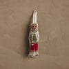The Coral & Tusk Dog with Gifts Ornament features a bear in a festive dog sweater and red pants, holding a tree and lantern, hanging by a fabric loop against a textured beige wall.