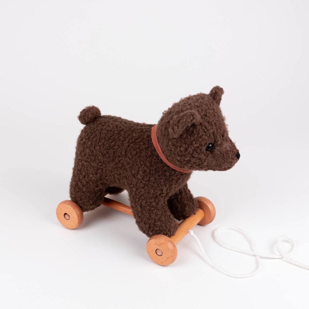 Pull-Along Raoul, a lovable Egmont Toys plush toy, is a brown pull-along bear with wooden wheels and a convenient pull string, shown against a plain white background.