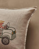 The Coral & Tusk Christmas Tree Car Pocket Pillow is a beige linen pillow with embroidered art of a bear in a hat driving a vintage green car, partially visible on the left side.