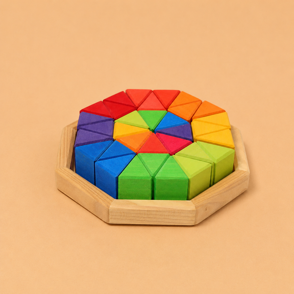 The Grimm’s Medium Octagon features colorful geometric wooden pieces, including triangle blocks, arranged in a circular pattern within an octagonal frame and displayed against a beige background. Crafted from non-toxic wood, it’s perfect for fans of geometric building toys.
