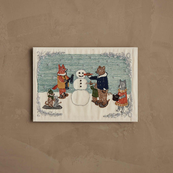 The Coral & Tusk Snowman Card features an embroidered fox, bear, and wolf building a snowman, with a rabbit and mouse on a sled, set against a pale green and beige background—perfect for winter decor or season’s greetings.