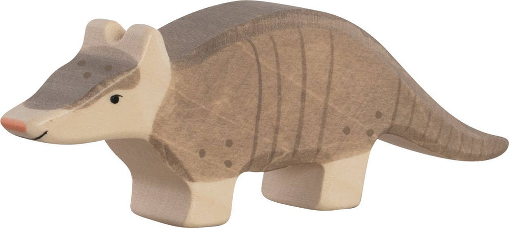 The Holztiger Armadillo is a handcrafted wooden toy, painted brown and gray with simple facial details, long tail, and short legs. Like all HOLZTIGER figures, it is made in Europe for quality and charm.