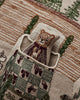 The Coral & Tusk Three Little Bears Pocket Pillow features a small fabric bear in a stitched pocket on an embroidered, checkered pillow with whimsical green and brown designs inspired by Goldilocks and the Three Bears. Ships in one week.