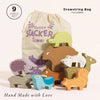 Nine colorful wooden forest animal stacking toys are arranged in front of a drawstring bag labeled “Woodland Stacking Forest Animals & Bag.” This woodland animals stacking set includes nine wooden animal blocks, a convenient drawstring bag, and the promise that each piece is “Hand Made with Love”—making it a charming and sustainable toy for imaginative play.