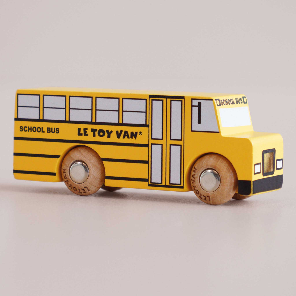 A yellow retro wooden No. 47 GT285 Rufus school bus, crafted in England, with “LE TOY VAN” and “SCHOOL BUS” inscribed on the side, black windows, and sturdy wooden wheels—perfect for imaginative journeys and bringing classic American charm to playtime.