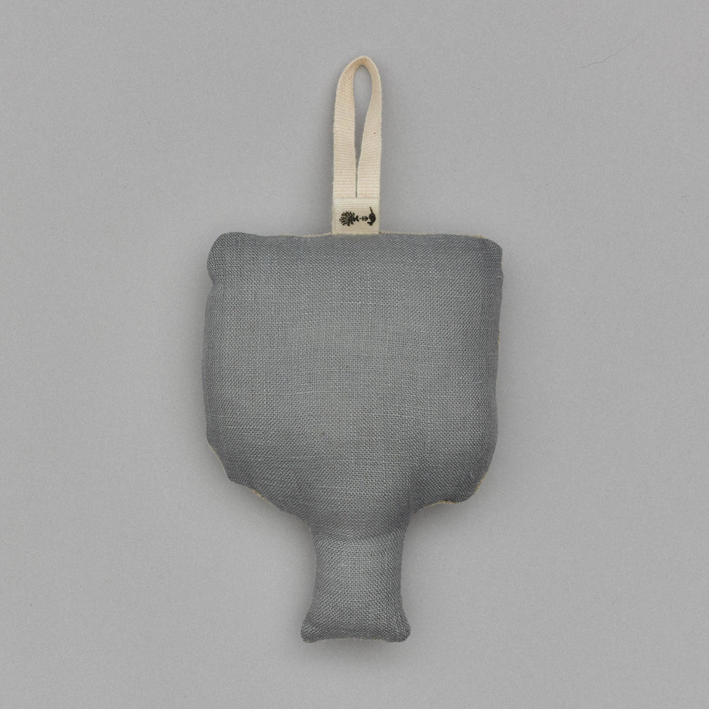 The Togetherness Deer Ornament is a gray plush toy shaped like a hammer, featuring a short handle and a loop for hanging at the top. It's perfect for adding a whimsical touch to your woodland holiday display, with its soft texture standing out against the plain, light gray background.