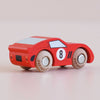 A small red wooden racing car, the No. 4 GT25 Finley made in England, with black detailing and a vintage-inspired design, sits on a light-colored surface.