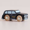 A wooden toy car inspired by the iconic London taxi, the No. 45 GT275 Bertie is painted black with “TAXI” written on the side, features silver windows, and has four round wooden wheels. Made in England.