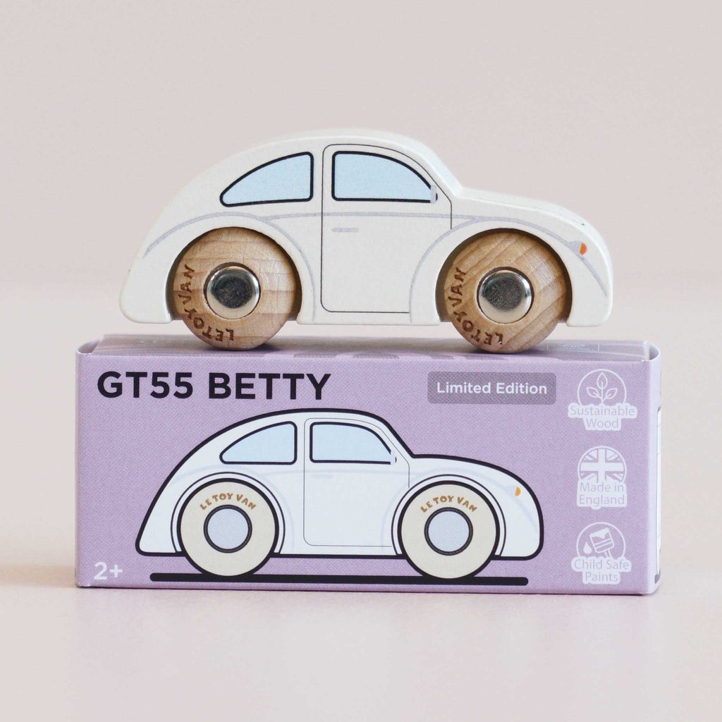 A classic white wooden No. 9 GT55 Betty car rests atop a purple box marked “Made in England.” The packaging highlights a nostalgic illustration of the toy alongside icons for sustainable wood, English craftsmanship, and child-safe paint—promising endless imaginative fun.