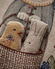The Coral & Tusk Easter Bunny Pocket Pillow features embroidered fabric toys—a yellow chick and a white bunny dressed in blue—nestled in a brown-patterned pocket, making it a charming Easter decoration.