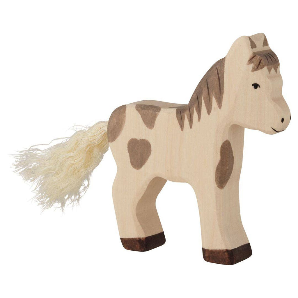 The Holztiger Foal, Standing is a handcrafted wooden toy horse with brown spots, a light-colored yarn tail, and simple features—made in Europe for timeless play.