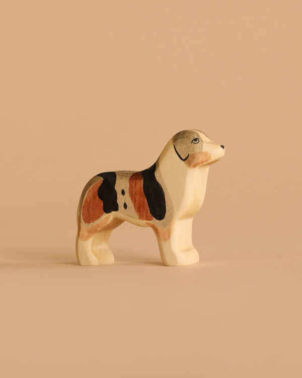The Handmade Holzwald Australian Shepherd is a small, hand-painted wooden toy dog with brown, black, and white markings—perfect for imaginative play or as a charming, sustainable addition to any toy collection.
