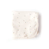 The Organic Baby Blanket – Schooner is a folded, cream-colored, chemical-free organic cotton blanket with a small sailboat pattern and an "oolie" fabric tag, displayed on a white background.
