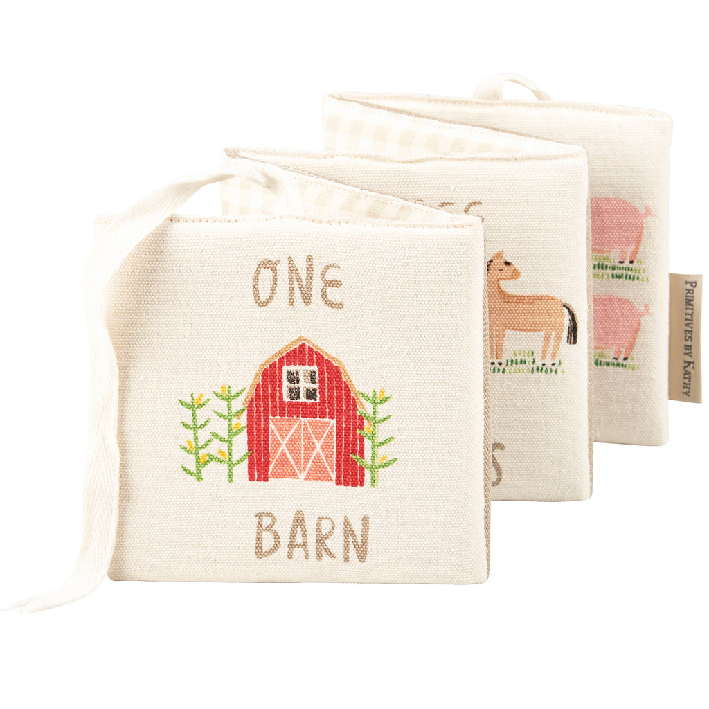 The Little Farm Soft Book is a soft infant book with embroidered farm animals. The front shows a red barn labeled "One Barn," and inside are charming illustrations of a horse and pigs, making it a delightful farm-themed gift.