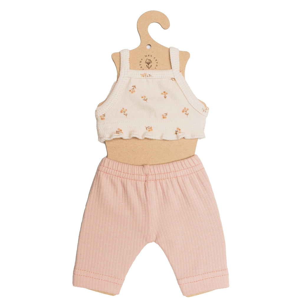 The Mrs. Ertha Doll Clothes - 13″-14″ - Flower Buds Leggings Set features a small hanger displaying a white crop top adorned with tiny orange flowers and light pink ribbed pants, both thoughtfully handmade for Minikane dolls or any cherished stuffed toy.