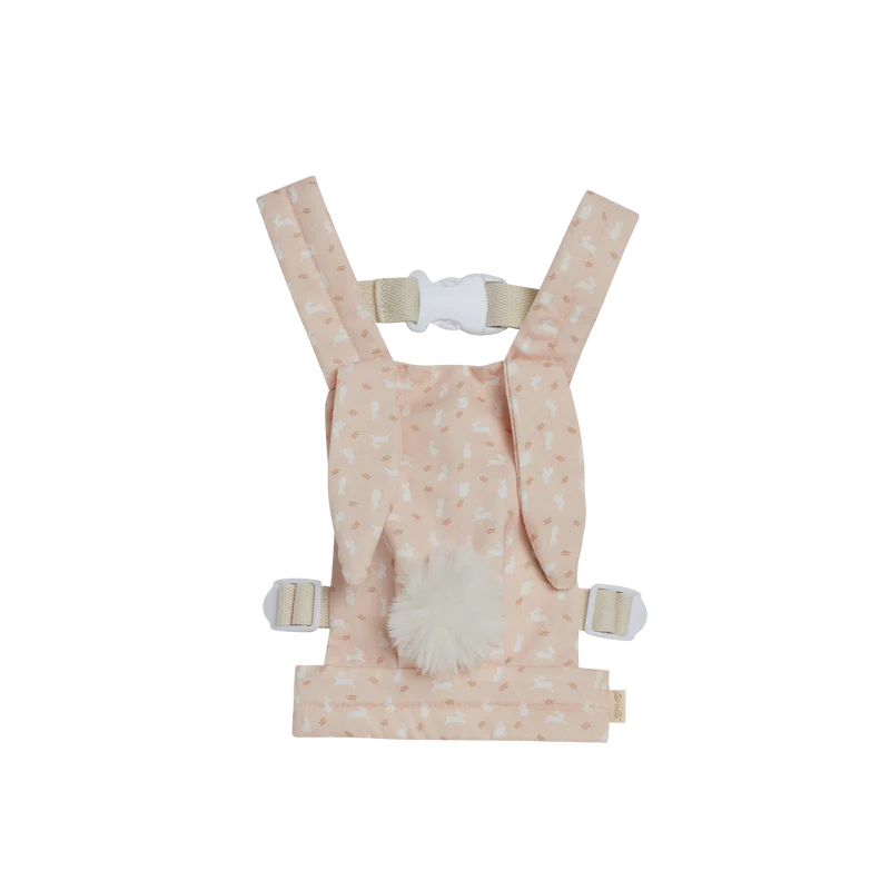 A peach-colored Olli Ella x Odin Parker Dinkum Dolls Cottontail Carrier – Lapin with a white fluffy tail and bow pattern, featuring adjustable straps and buckles, displayed against a black background.