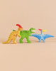 Holztiger Handmade Wooden Dinosaur Set featuring three figures for imaginative play: a yellow parasaurolophus, a green tyrannosaurus, and a blue pterosaur.