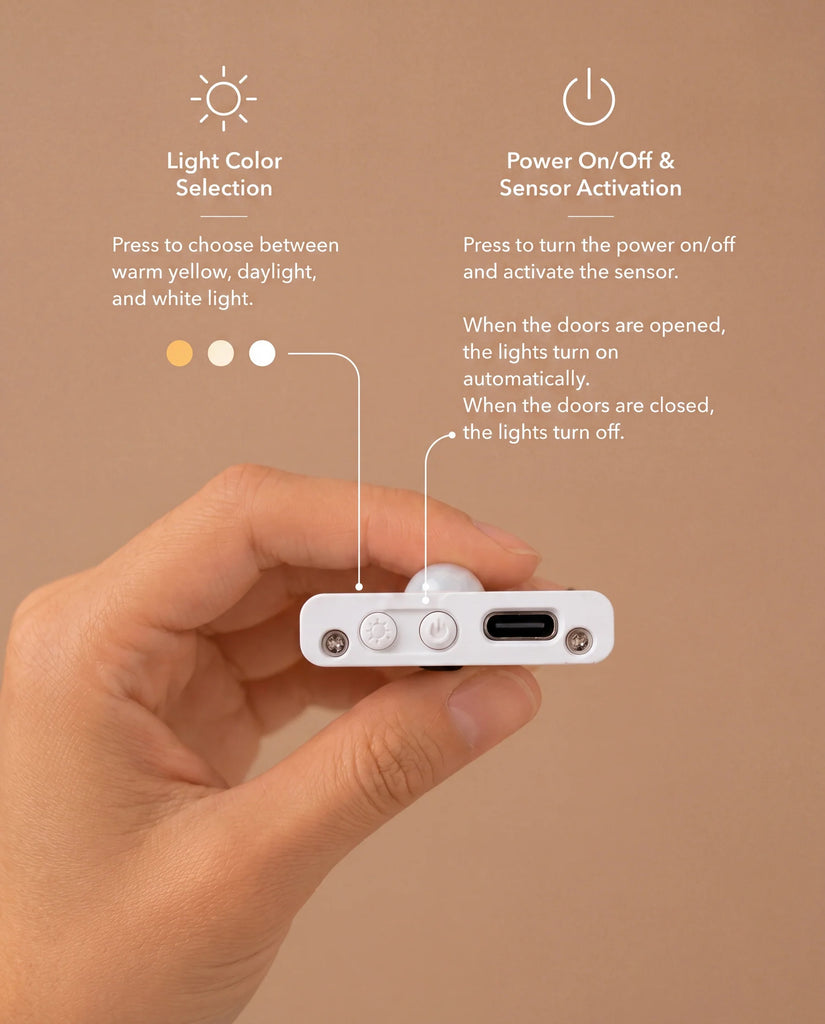A hand holds a small device with buttons labeled for light color selection and power/sensor activation, against a beige background, accompanied by instructional text detailing each button’s function—perfect for enhancing the ambiance of your House of Paris Luxury Dollhouse – A Tale of Parisian Magic.