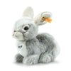 The Steiff Dormili Rabbit is a soft gray and white plush toy that sits upright, featuring a Steiff tag in its ear and a round chest label—an adorable bunny stuffed animal perfect for play or display.