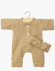 The Minikane 11" Doll Clothing set features the Lili Jumpsuit & Headband in Latte cotton gauze, displayed on a wooden hanger with the matching bow headband across the front, all set against a plain white background.