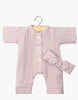 The Minikane 11" Doll Clothing set features the Lili Jumpsuit & Headband in soft orchid pink cotton gauze—long-sleeve romper with white buttons and matching bow headband, perfect for dressing up your Minikane doll.